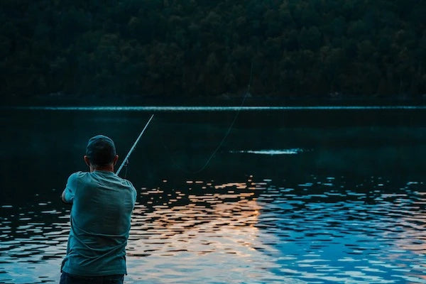 fisherman casts off on lake